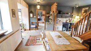 A cozy kitchen with a dining area, wooden furniture, and a staircase leading to another level. - The Waggon Shed (Nottingham)
