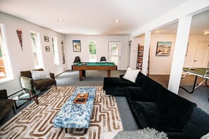 A living room with a pool table, two sofas, a coffee table, and a billiards table. - Riverfront FirePit! HotTub-Pool-Beaches-Gameroom (Gouldsboro)