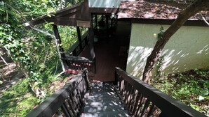 A wooden staircase leading to a covered area with a sign reading "Appleton Lodge." - Quaint cottage with a beautiful view. (Greenville)