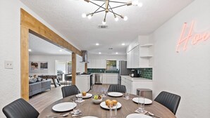 Zona de menjador moderna amb una taula de fusta preparada per a sis persones, amb cadires negres al voltant.