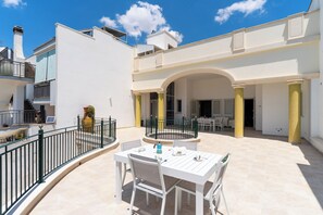 A white outdoor patio with a table and chairs, a circular seating area, and a building with balconies and a covered walkway. - 3558 Dimora Don Attilio by Barbarhouse (Sannicola)