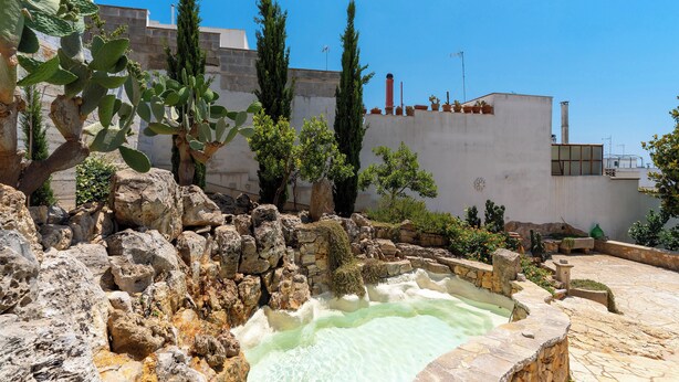 A courtyard with a hot spring, stone walls, cacti, and potted plants. - 3558 Dimora Don Attilio by Barbarhouse (Sannicola)