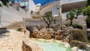 A courtyard with a stone pool, cactus plants, and a white building with balconies. - 3558 Dimora Don Attilio by Barbarhouse (Sannicola)