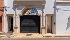 A building with a large black double door, a white facade, and a stone-paved entrance. - 3558 Dimora Don Attilio by Barbarhouse (Sannicola)