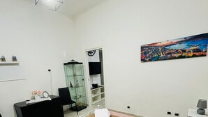 Ein Schlafzimmer mit Bett, Schreibtisch, Stuhl, Kleiderschrank und einem Bild an der Wand.