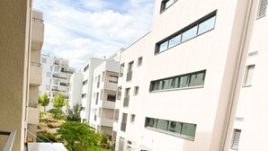 Un immeuble d’appartements moderne avec une cour étroite.