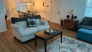 Un salon avec un canapé, une table basse et un tapis à motifs.