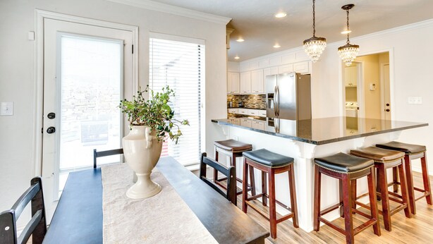 A modern kitchen with a central island, bar stools, and pendant lighting. - < 1 Mi to OU Campus - Norman Vacation Rental (Norman)