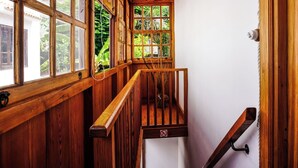 A wooden staircase with a railing, a window with a view of greenery, and a white wall. - Casa Yeyo, Lomo Bermejo (Santa Cruz de Tenerife)