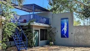 Ein Gebäude mit einem blauen Balkon, einer Satellitenschüssel und einem Vogelgemälde an der Wand.