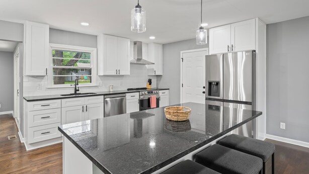 A modern kitchen with white cabinets, stainless steel appliances, and a central island with seating. - Sleek & Affordable 3 Bedroom/2 Bath in downtown Overland Park! (Overland Park)