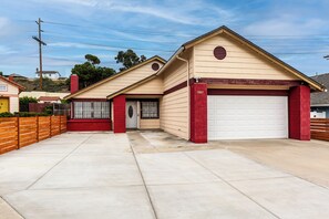 Stylish home with a garage, brick chimney, and cozy porch area.