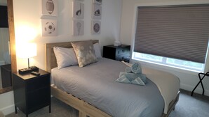 A neatly arranged bedroom with a bed, bedside tables, a lamp, and wall art. - Family-friendly home, dedicated workspace, minutes from Cincinnati attractions! (Cincinnati)