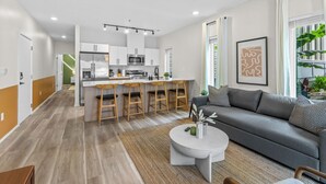 Un appartement moderne comprenant une cuisine, un coin repas et un salon.