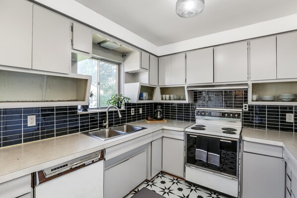 Enjoy cooking in this well-lit kitchen with a stainless steel sink, oven, and dishwasher.