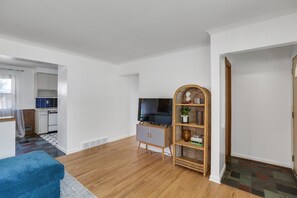 Relax in a bright and airy space with a flat-screen TV, wicker sideboard, and comfortable bench.