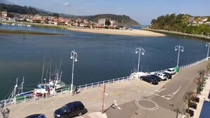 Une vue sur le front de mer, avec un port de plaisance, des voitures garées et des bâtiments en arrière-plan.