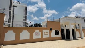 A modern building with a sign for Da-Ajji Homes advertising one-bedroom houses for rent. - Diani Bliss-Where Luxury Meets the Ocean Breeze.” (Mombasa)