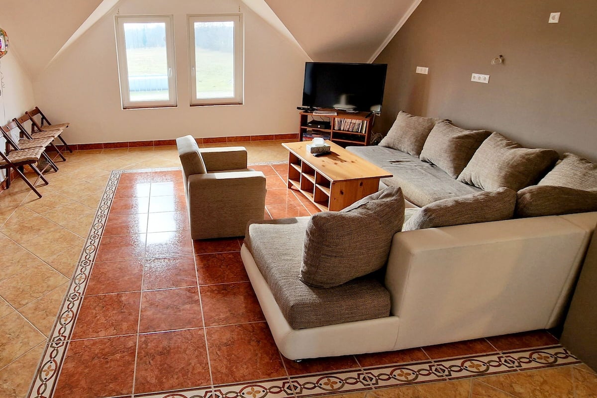 A living room with a sectional sofa, a TV, and a wooden coffee table.
