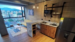 Una cucina moderna con piano di lavoro in legno, forno integrato e frigorifero. Ampia finestra con vista sulla città.