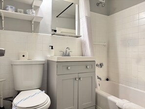 A bathroom with a toilet, sink, and bathtub. - ATL Downtown 2B Condo with Free Parking (Atlanta)