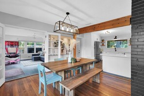 Relax in this open-plan living space with a central dining table and comfortable seating.