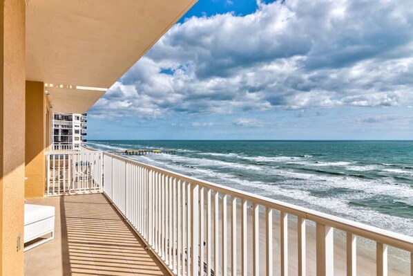 Un balcon avec vue sur l’océan et sur une jetée.