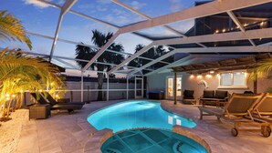 Une piscine extérieure avec des chaises longues et un patio couvert.