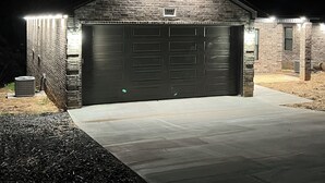 A brick garage with two doors, illuminated by exterior lights, and a number "319" sign above the entrance.