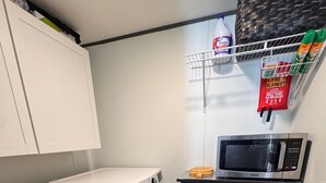 A compact laundry room with a washing machine, a dryer, a microwave, and a small storage cabinet. - Charming Mountain Retreat Near Grayson Highlands, 2BR 2BA, Sleeps 6 (Mouth of Wilson)