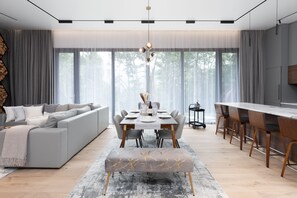 Et moderne spiseområde med et langt bord, grå polstrede stole og en bænk.