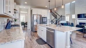 Una cocina moderna con armarios blancos, electrodomésticos de acero inoxidable y una isla central.