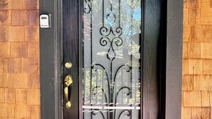 A black-framed door with a decorative glass panel and a brass door handle.