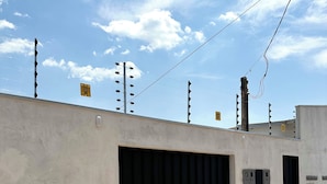 A building with a large garage door, a paved area, and utility poles with wires.