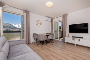 Un salon moderne comprenant un canapé, une table à manger, des chaises et un téléviseur.