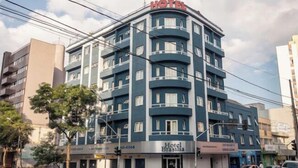 Un hotel de varios pisos con fachada azul, balcones y el letrero 'Hotel Brasilia'.