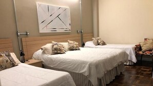 Habitación de hotel con dos camas, cabecero de madera, una obra de arte colgada en la pared y una alfombra estampada.