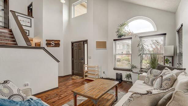 Ein geräumiges Wohnzimmer mit einem Couchtisch aus Holz, einer Couch und einer Treppe, die zu einer anderen Ebene führt.