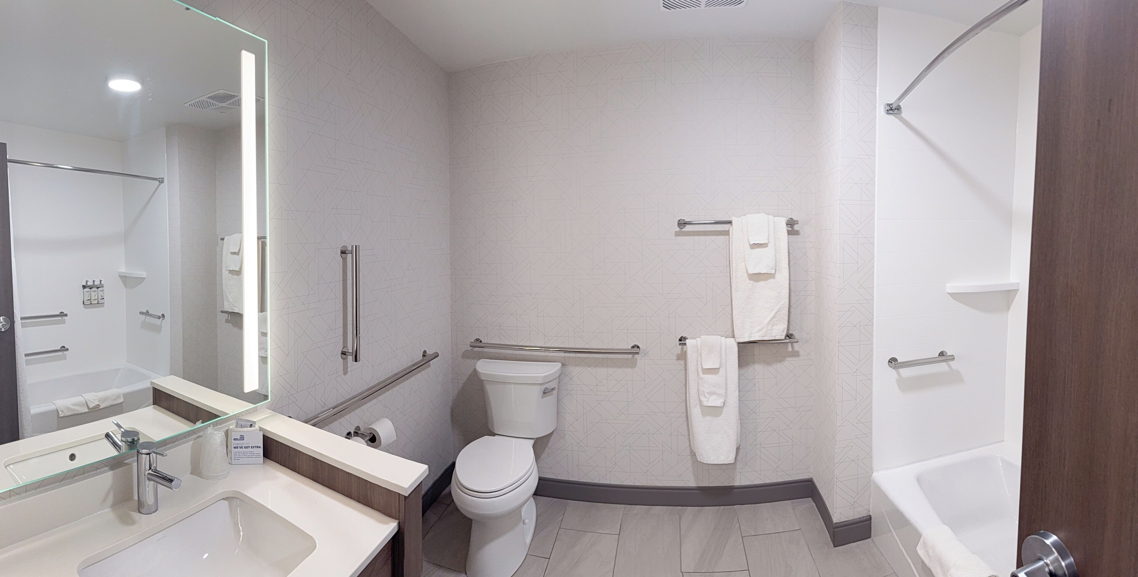 Een moderne badkamer met een glazen douchecabine, een apart toilet en een bad.