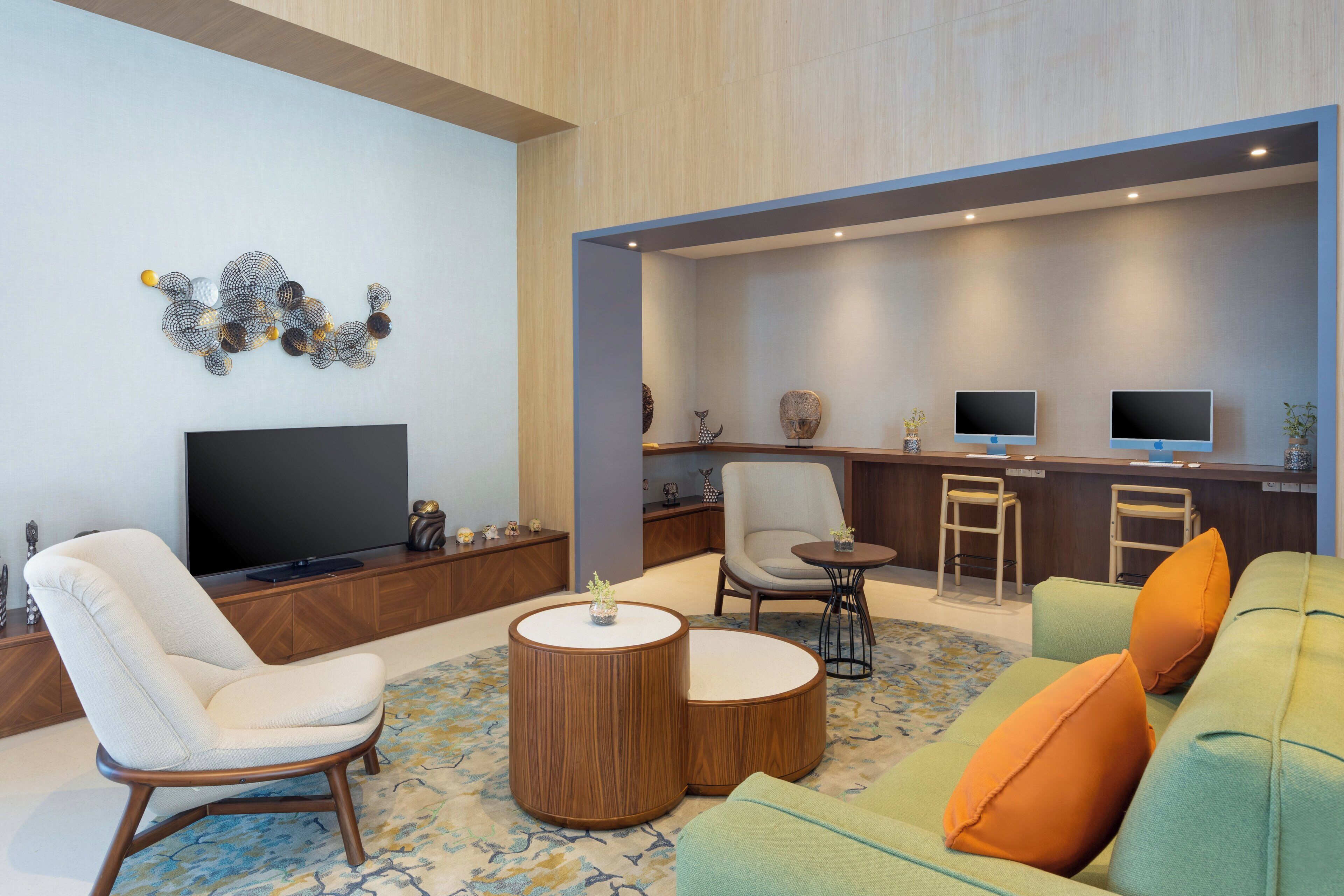 A modern living room with a flat-screen TV, a comfortable sofa, a wooden coffee table, and a bar area with stools.
