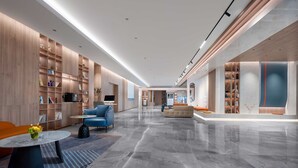 A spacious lobby with a marble floor, modern furniture, and built-in bookshelves. - Holiday Inn Express Suzhou Shihu University Town by IHG (Suzhou)