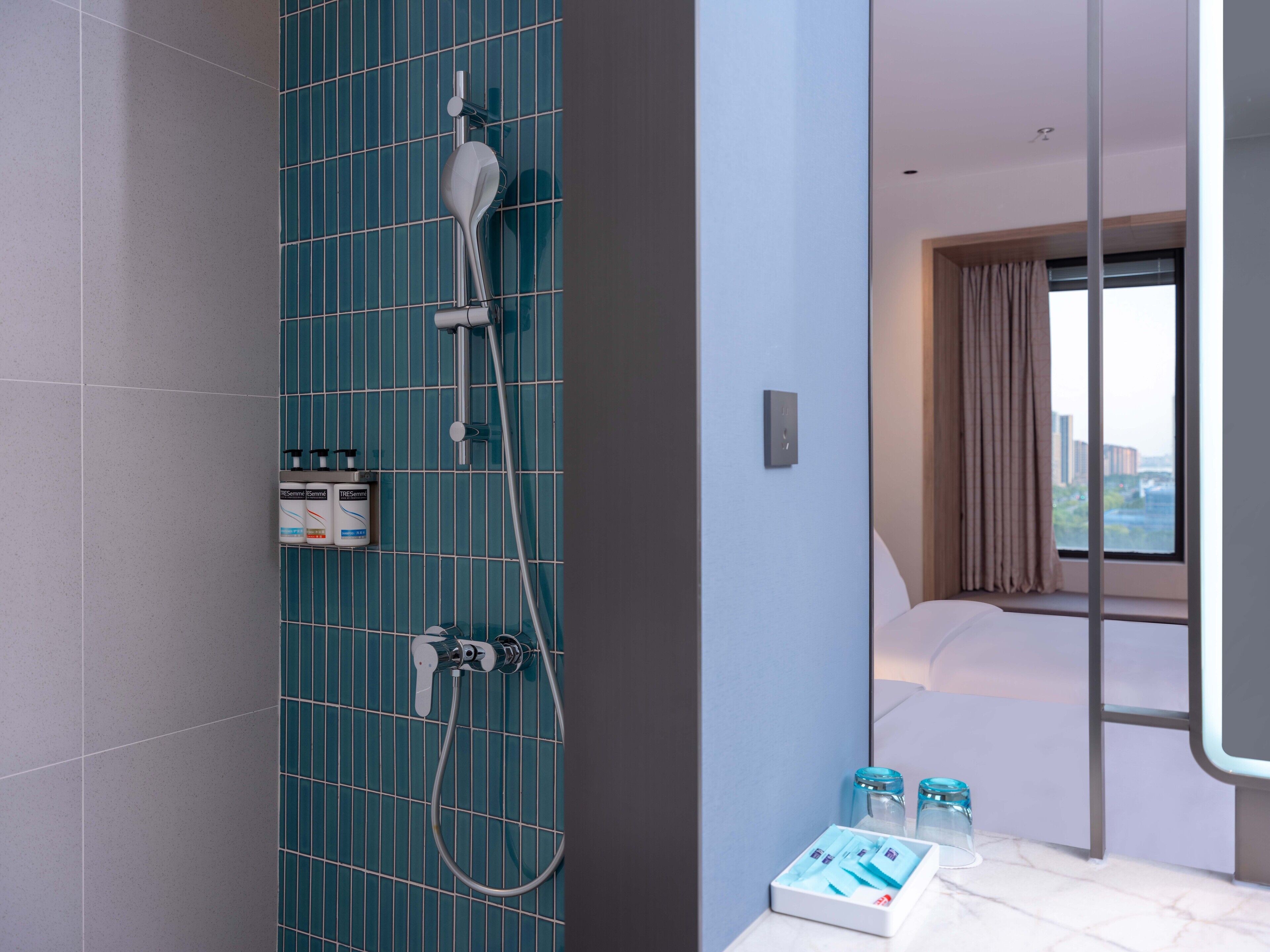 Een moderne badkamer met een douche, toilet en wastafel. Er staan toiletartikelen op het aanrecht.
