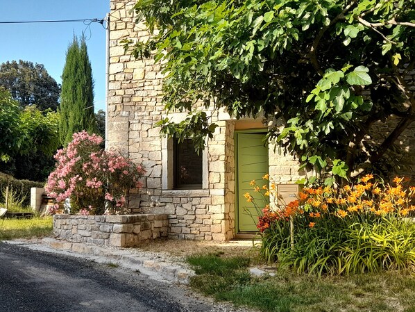 A stone building with a green door, a small window, and a stone wall. - Villa Moderne Tout Confort Dans mas Avec Piscine, Proche Pic Saint Loup (Valflaunès)