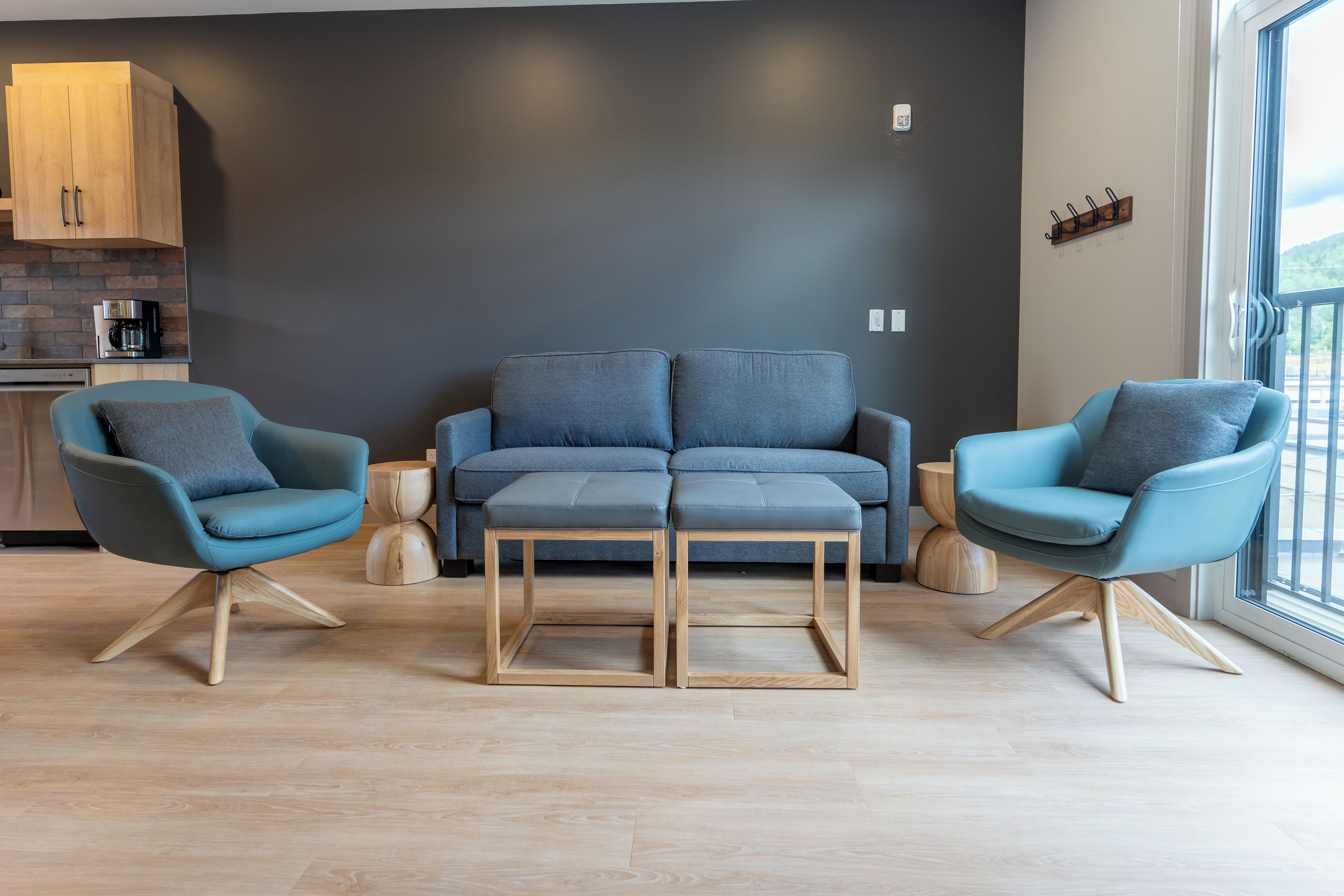 A modern living room with a grey sofa, two matching armchairs, and a wooden coffee table.