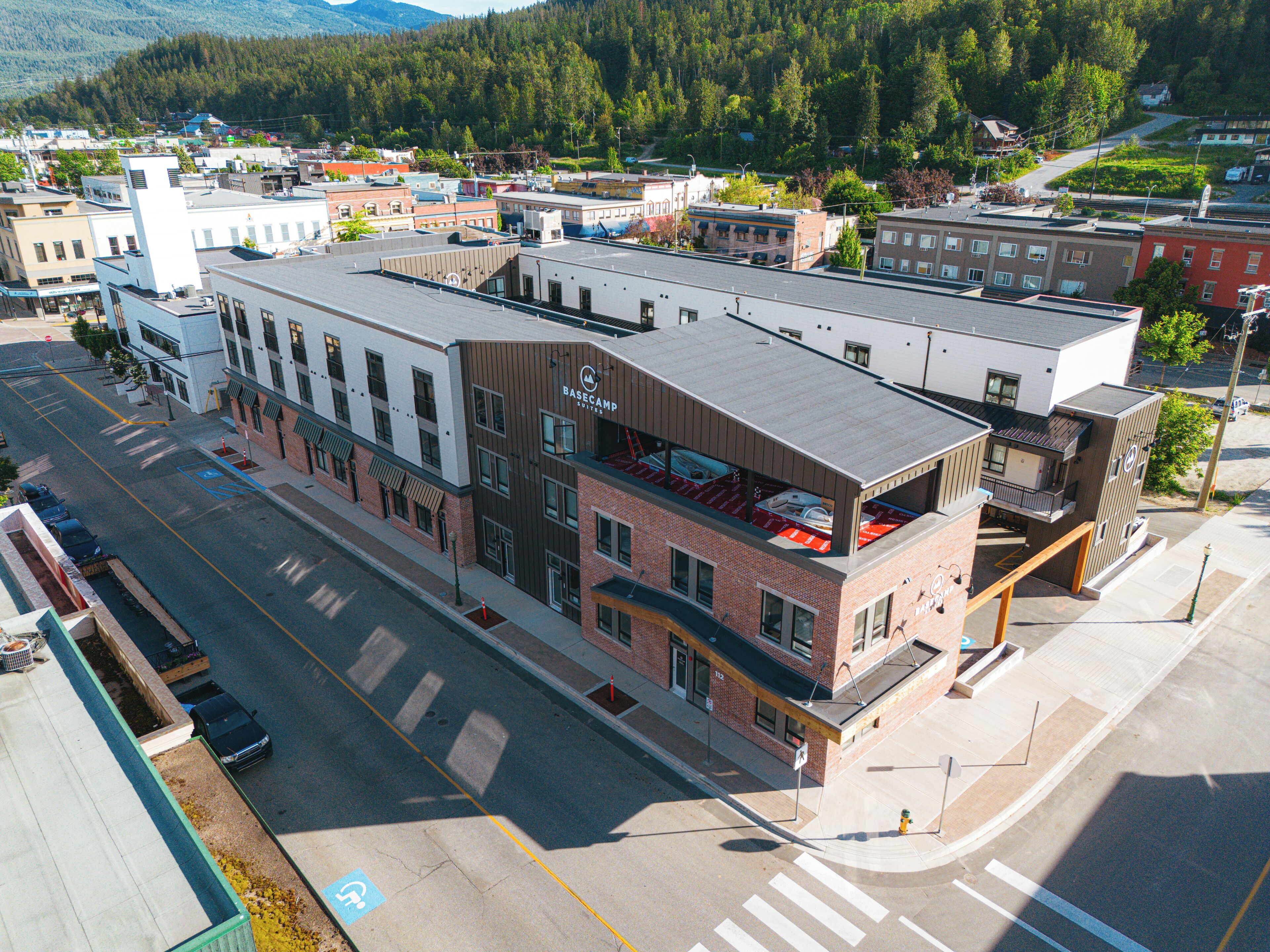 A multi-story hotel with a flat roof, a ground-floor restaurant, and a parking lot.