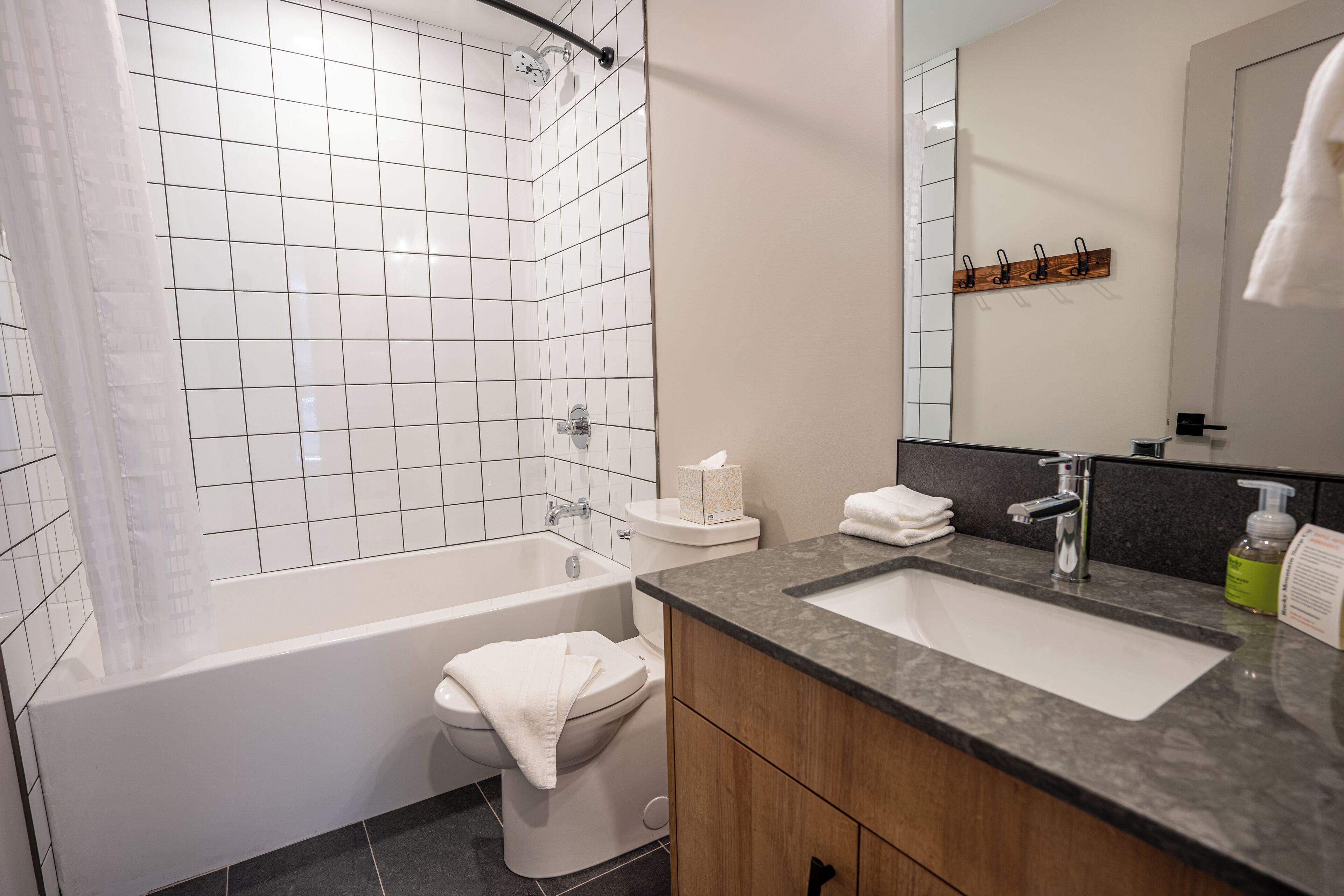 A modern bathroom with a bathtub, toilet, and sink.