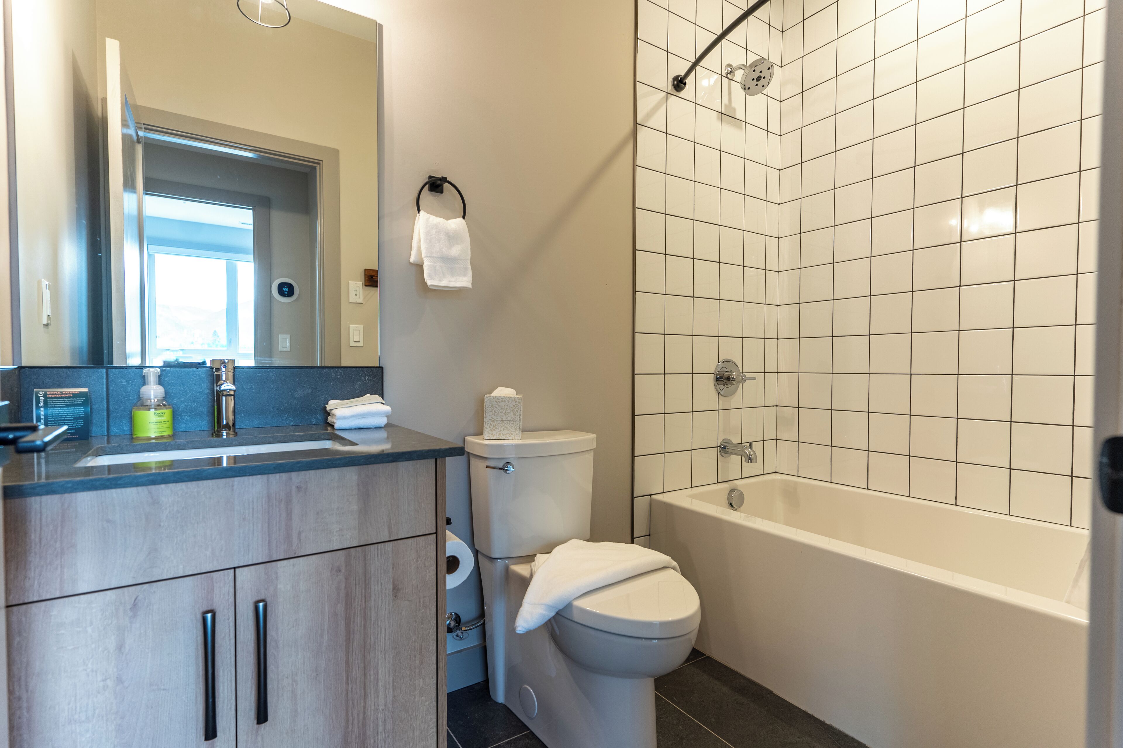 Un baño moderno con inodoro, lavamanos y bañera.