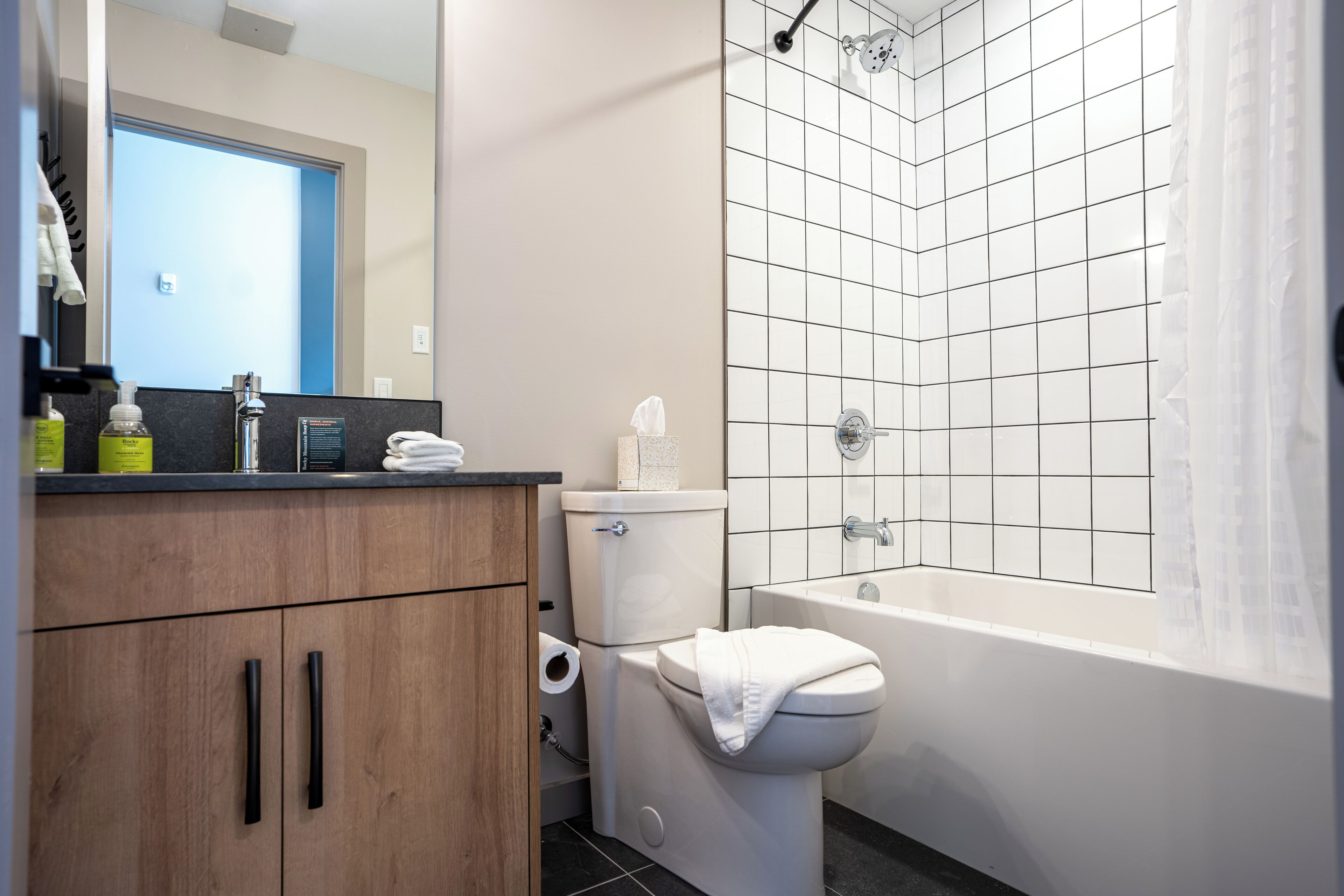 Un bagno moderno con il water, lavandino e vasca.