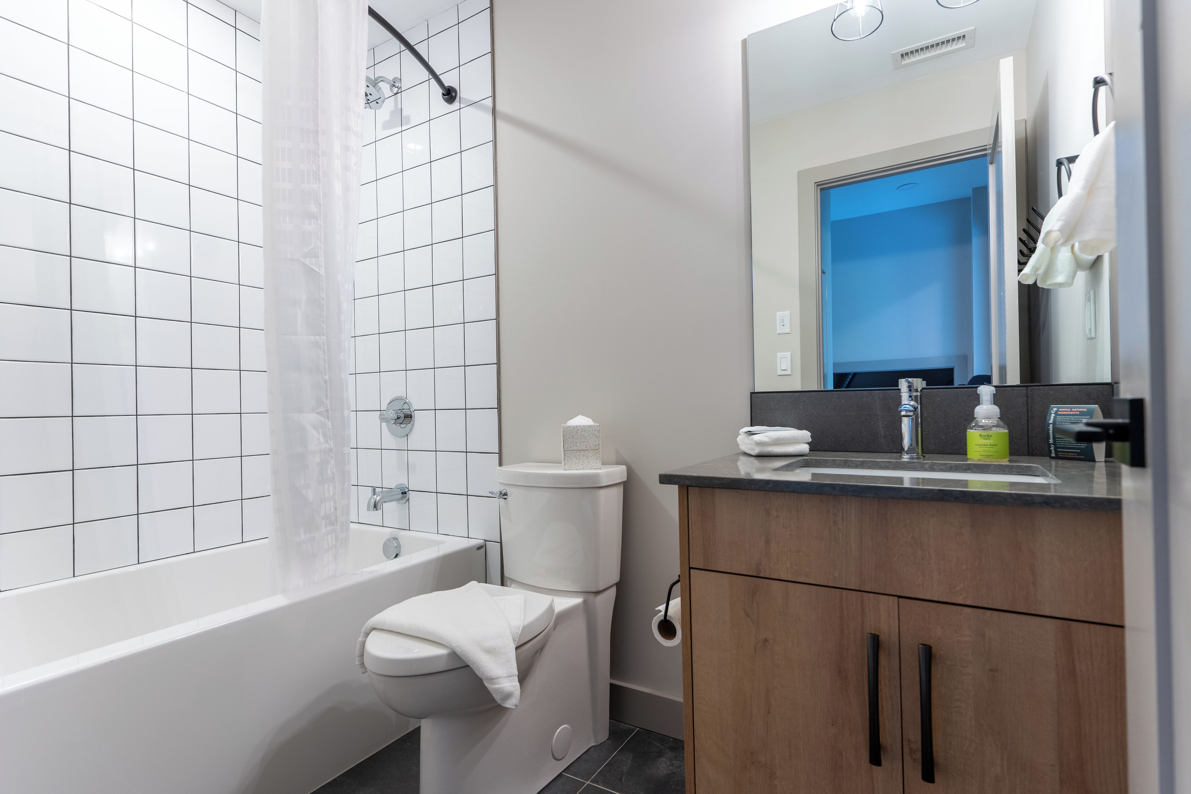 A modern bathroom with a bathtub, toilet, and sink.
