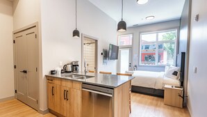 Una cocina moderna con lavavajillas, armarios de madera y un amplio ventanal.